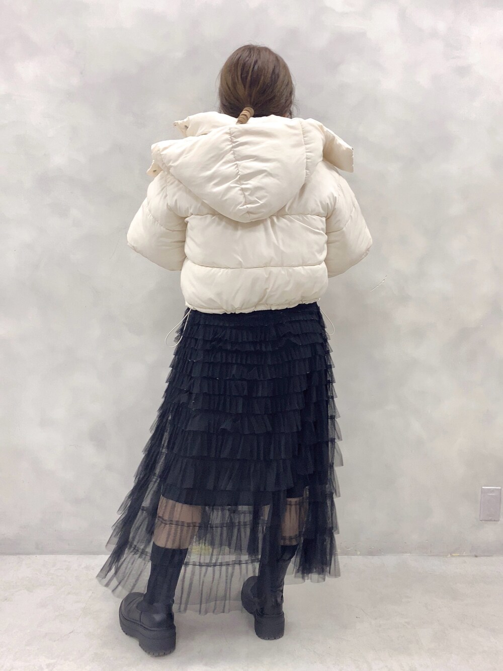 ホワイト系のダウンジャケット/コート、ホワイト系のニット/セーター、ブラック系のスカートを着用したレディースの冬コーディネートの4枚目の写真