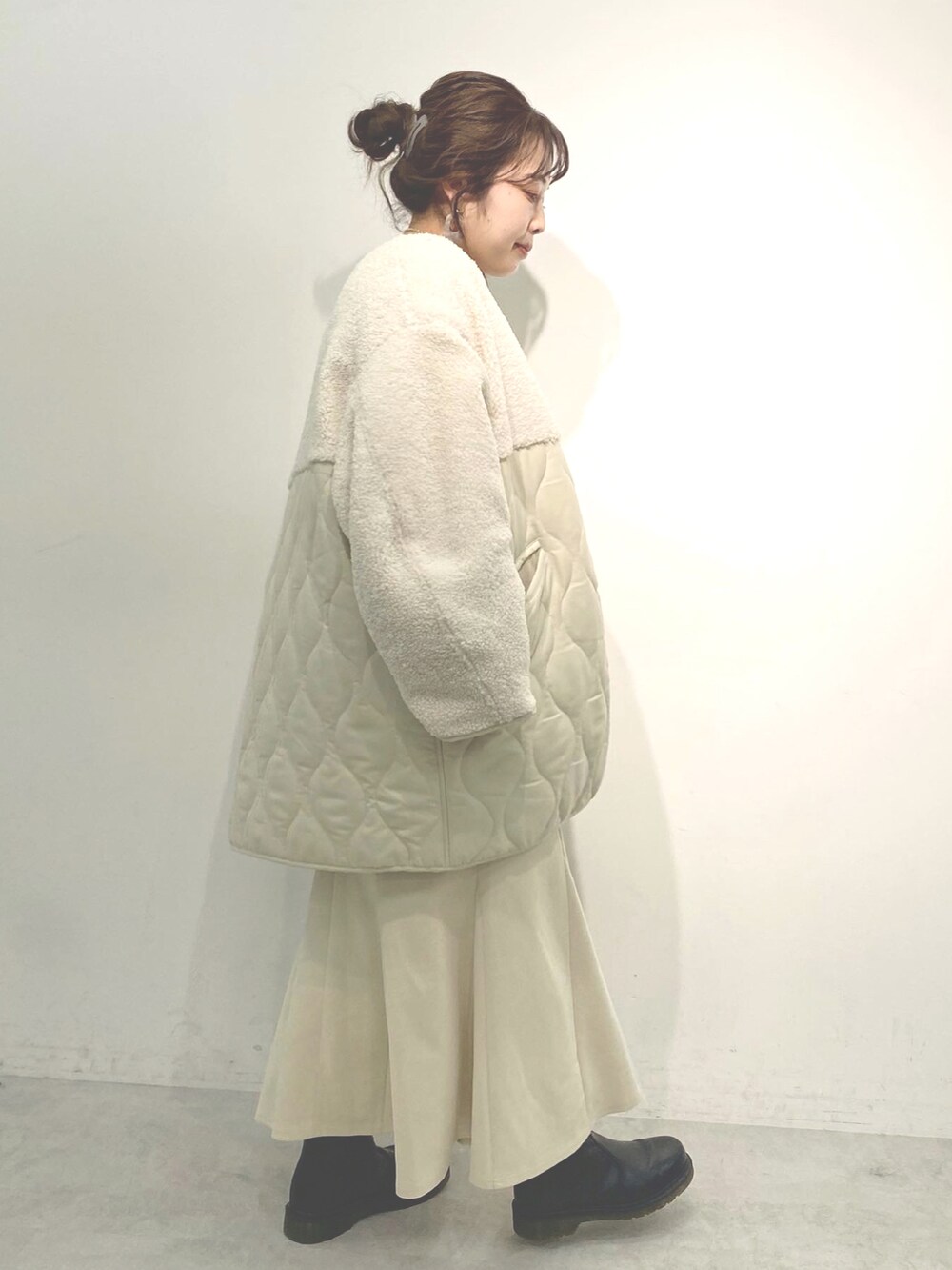 ホワイト系のニット/セーター、ホワイト系のノーカラーコート、ホワイト系のスカートを着用したレディースの冬コーディネートの2枚目の写真
