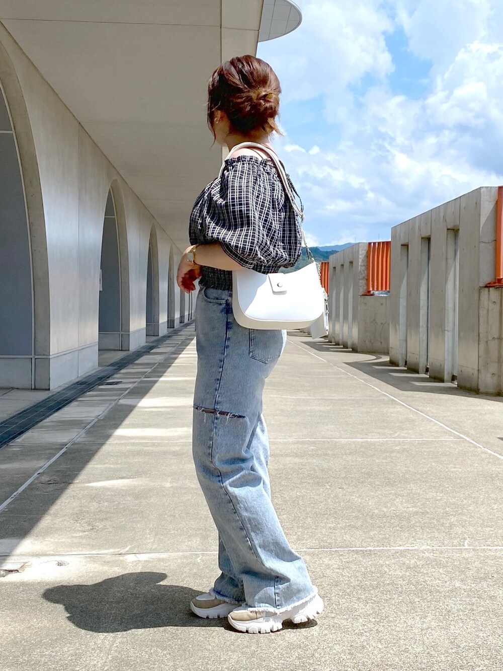 ブラック系のシャツ/ブラウス、ブルー系のデニムパンツ、ベージュ系のスニーカーを着用したレディースの夏コーディネートの2枚目の写真