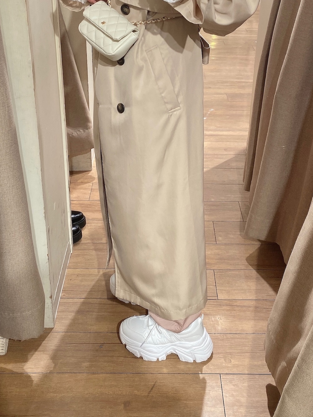 ベージュ系のトレンチコート、ピンク系のカーゴパンツ、ホワイト系のTシャツ/カットソーを着用したレディースの冬コーディネートの3枚目の写真
