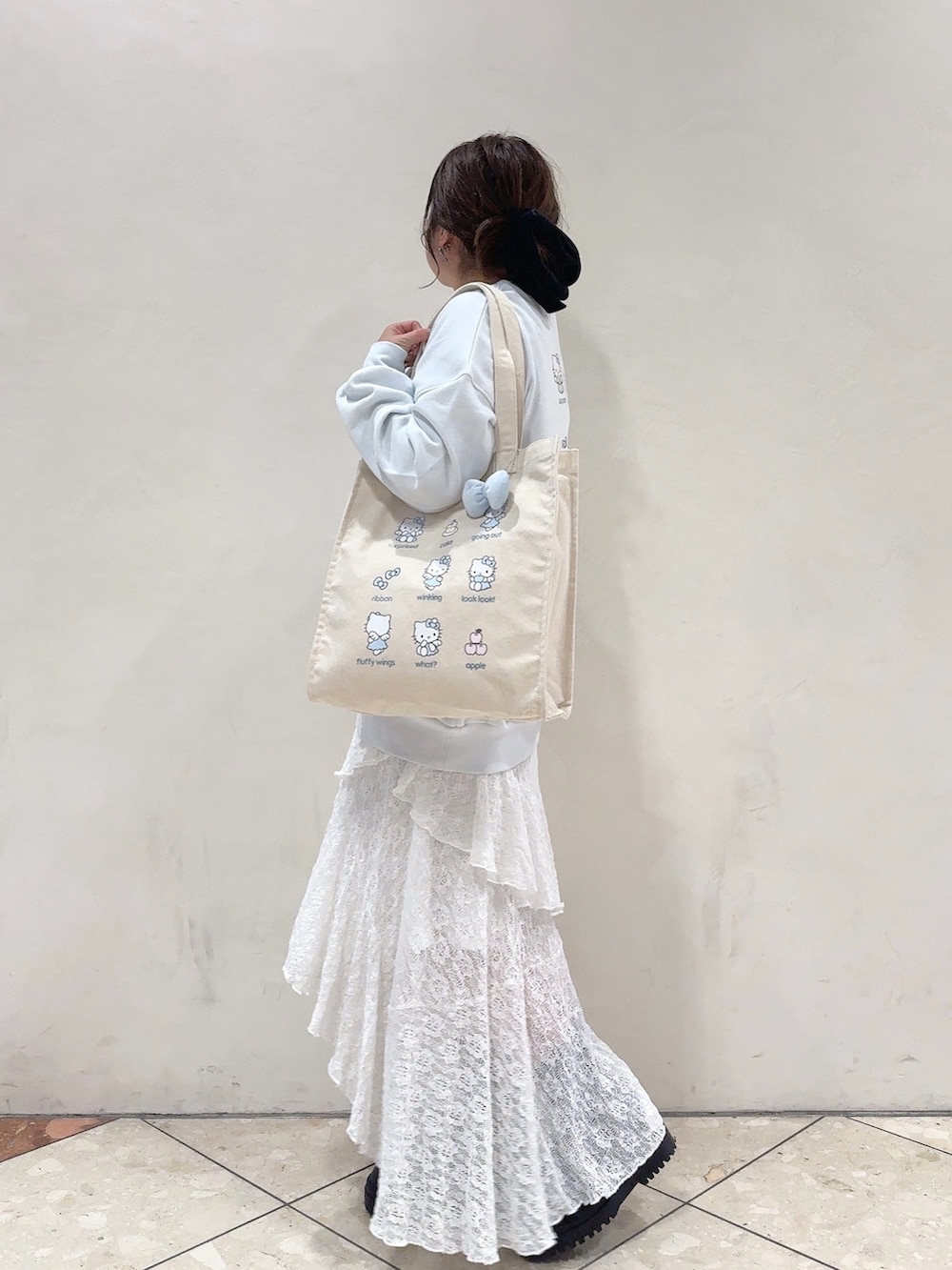 ブルー系のスウェット、ホワイト系のワンピース、ブルー系のトートバッグを着用したレディースの冬コーディネートの3枚目の写真