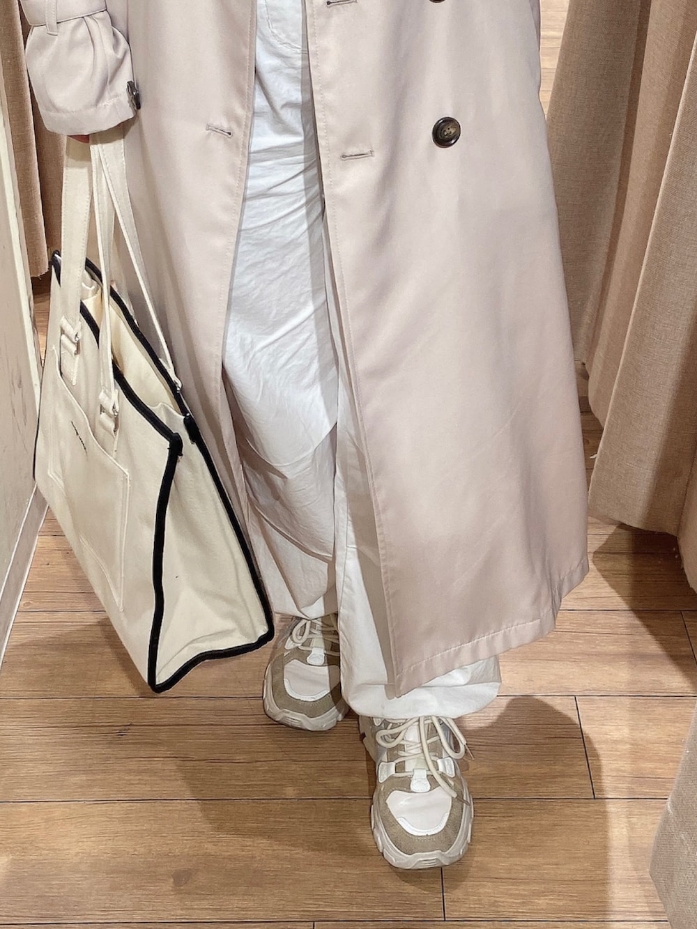 ベージュ系のトレンチコート、ホワイト系のTシャツ/カットソー、ホワイト系のカーゴパンツを着用したレディースの冬コーディネートの3枚目の写真