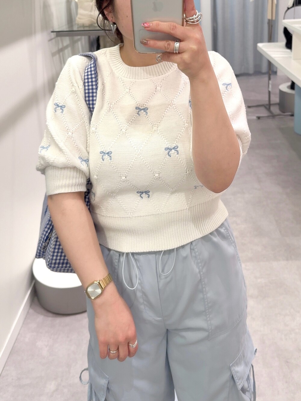 ホワイト系のニット/セーター、ブルー系のカーゴパンツ、ホワイト系のスニーカーを着用したレディースの春コーディネートの2枚目の写真