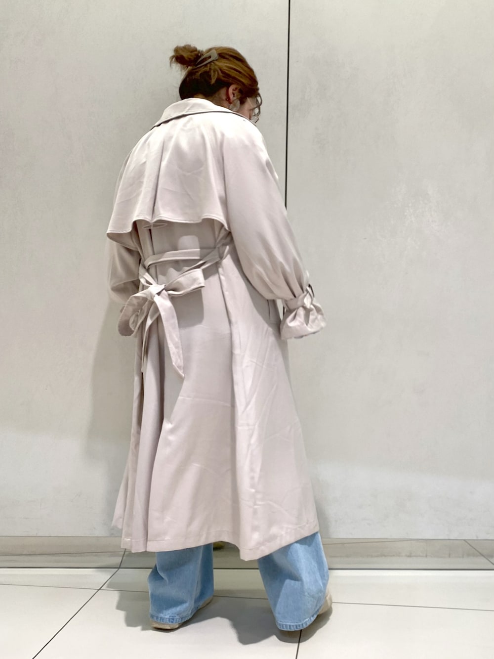 ブルー系のシャツ/ブラウス、ベージュ系のトレンチコート、ブルー系のデニムパンツを着用したレディースの春コーディネートの2枚目の写真