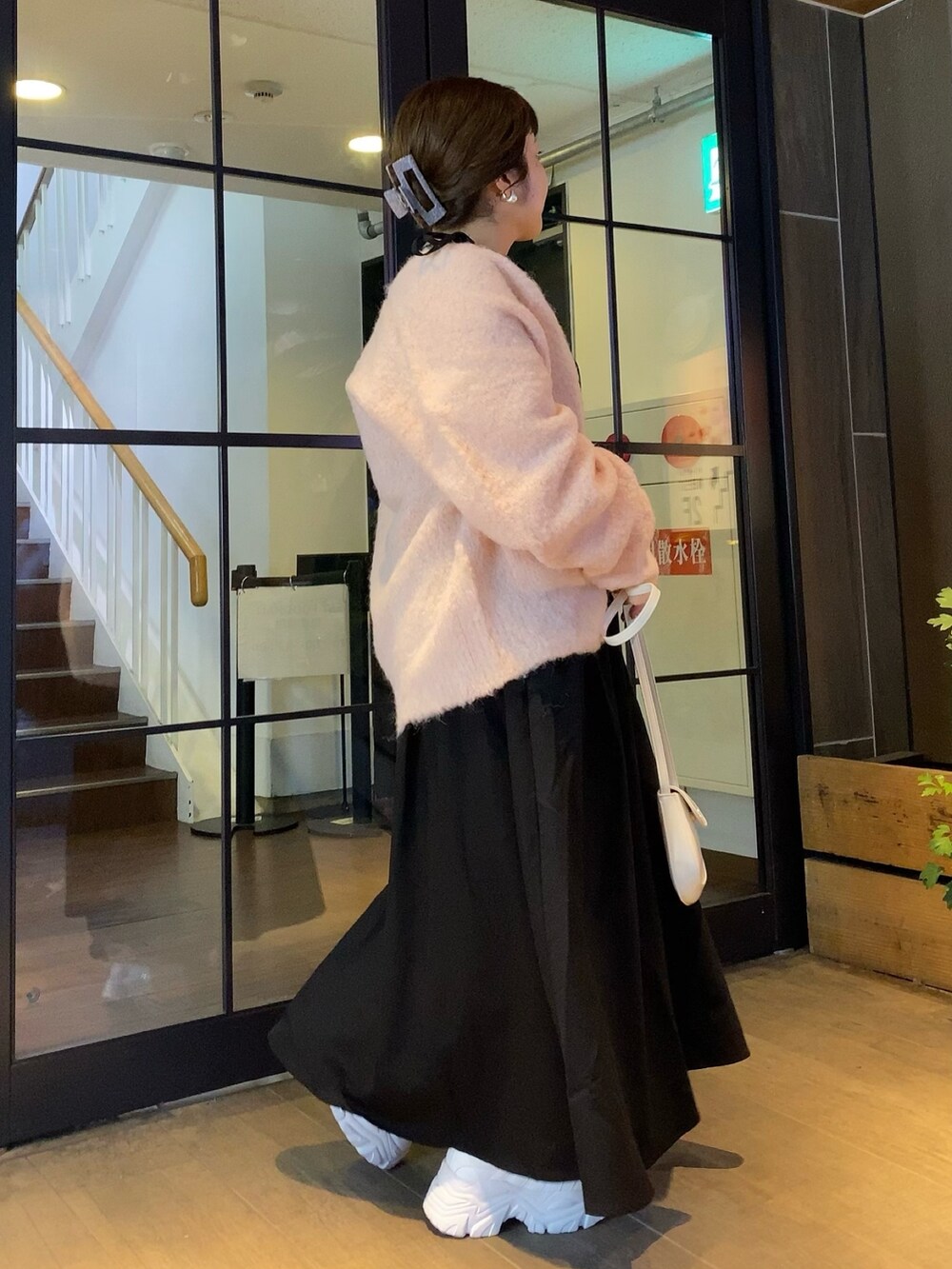 ピンク系のカーディガン/ボレロ、ブラック系のワンピース、ホワイト系のスニーカーを着用したレディースの秋コーディネートの3枚目の写真