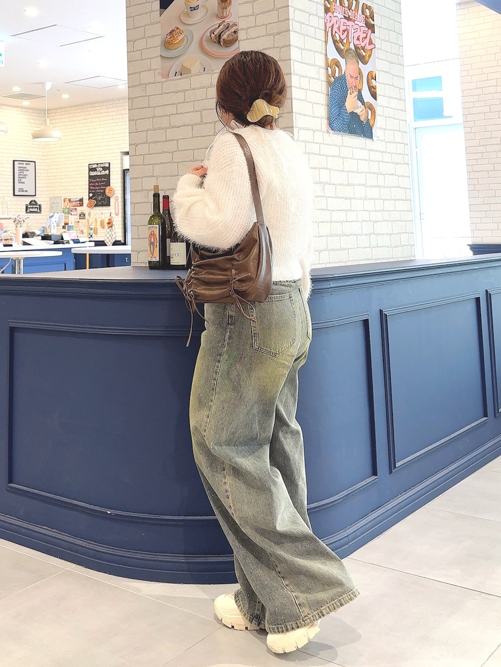 ホワイト系のカーディガン/ボレロ、ホワイト系のアンサンブル、ブルー系のデニムパンツを着用したレディースの秋コーディネートの3枚目の写真