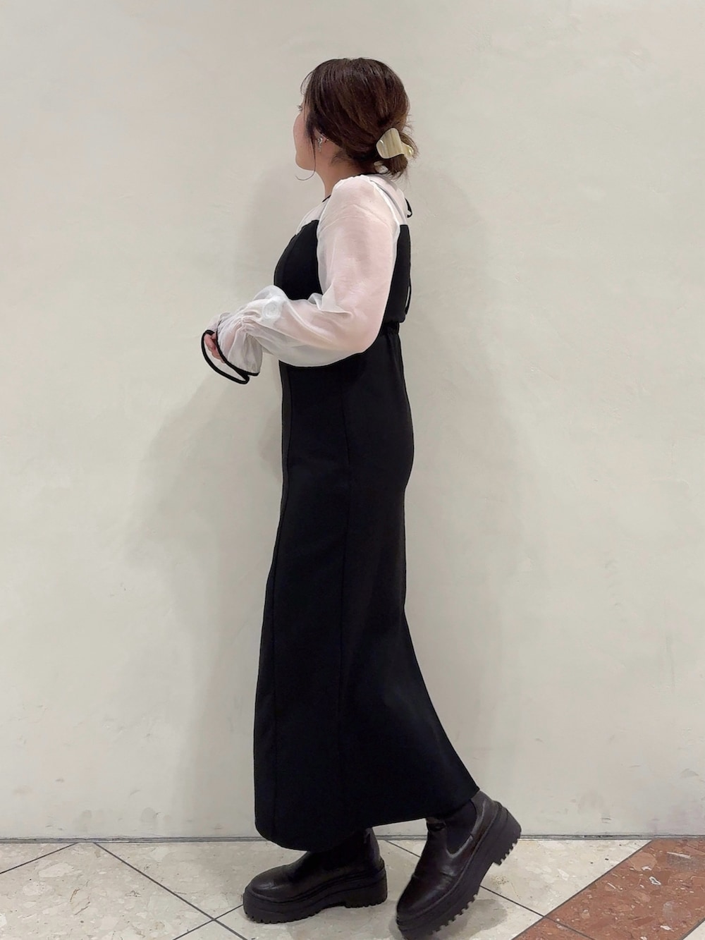 ブラック系のドレス、ブラウン系のブーツを着用したレディースの秋コーディネートの3枚目の写真