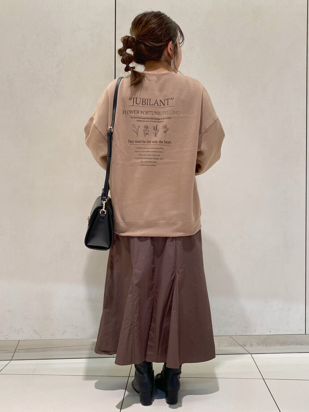 ベージュ系のスカート、ブラック系のショルダーバッグ、ベージュ系のスウェットを着用したレディースの秋コーディネートの2枚目の写真