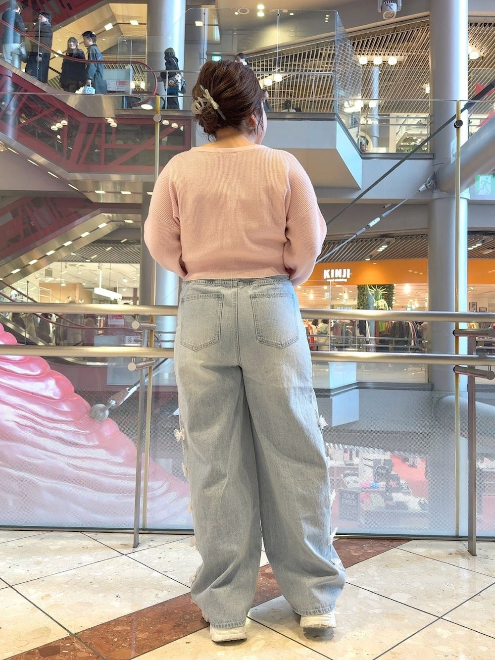 ピンク系のカーディガン/ボレロ、ブルー系のデニムパンツ、ホワイト系のショルダーバッグを着用したレディースの冬コーディネートの4枚目の写真