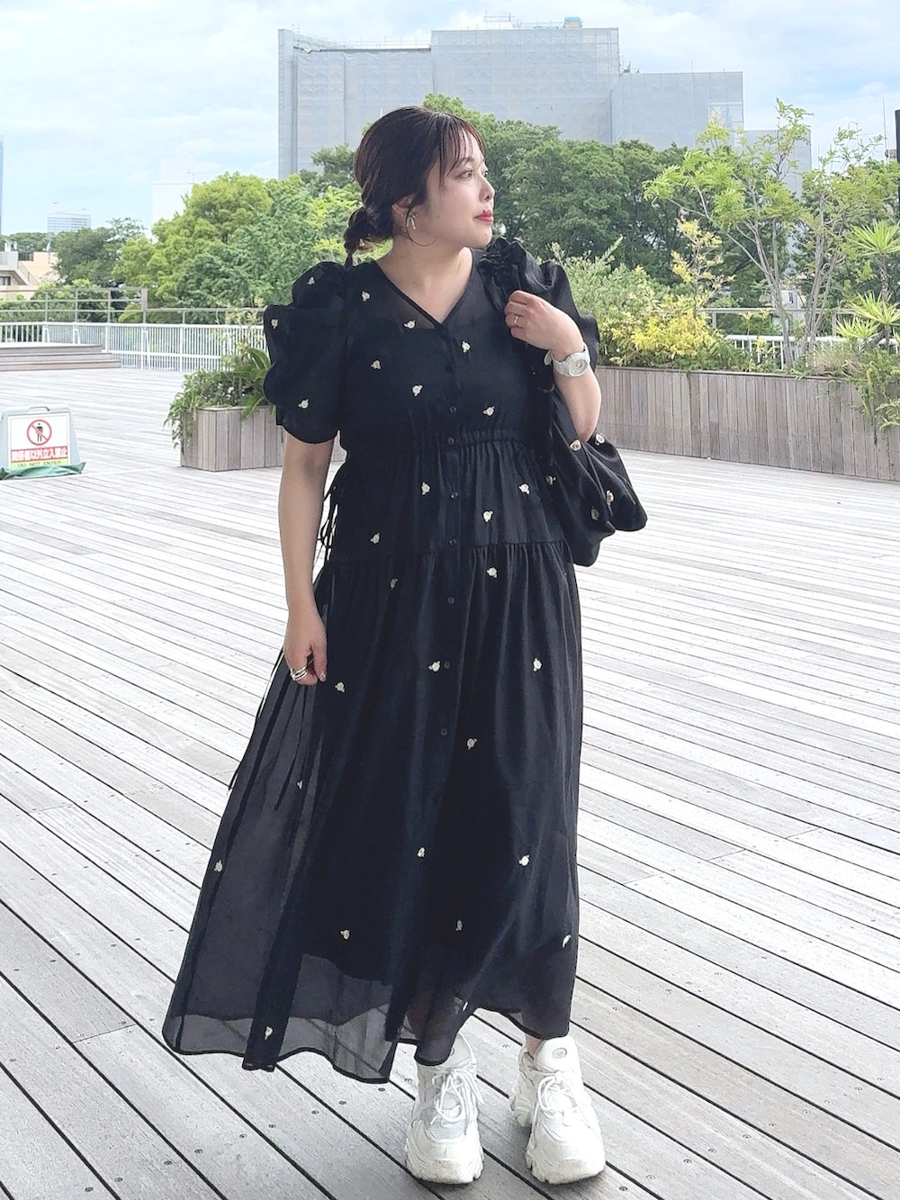 ブラック系のワンピース、ブラック系のショルダーバッグ、ホワイト系のスニーカーを着用したレディースの夏コーディネートの2枚目の写真