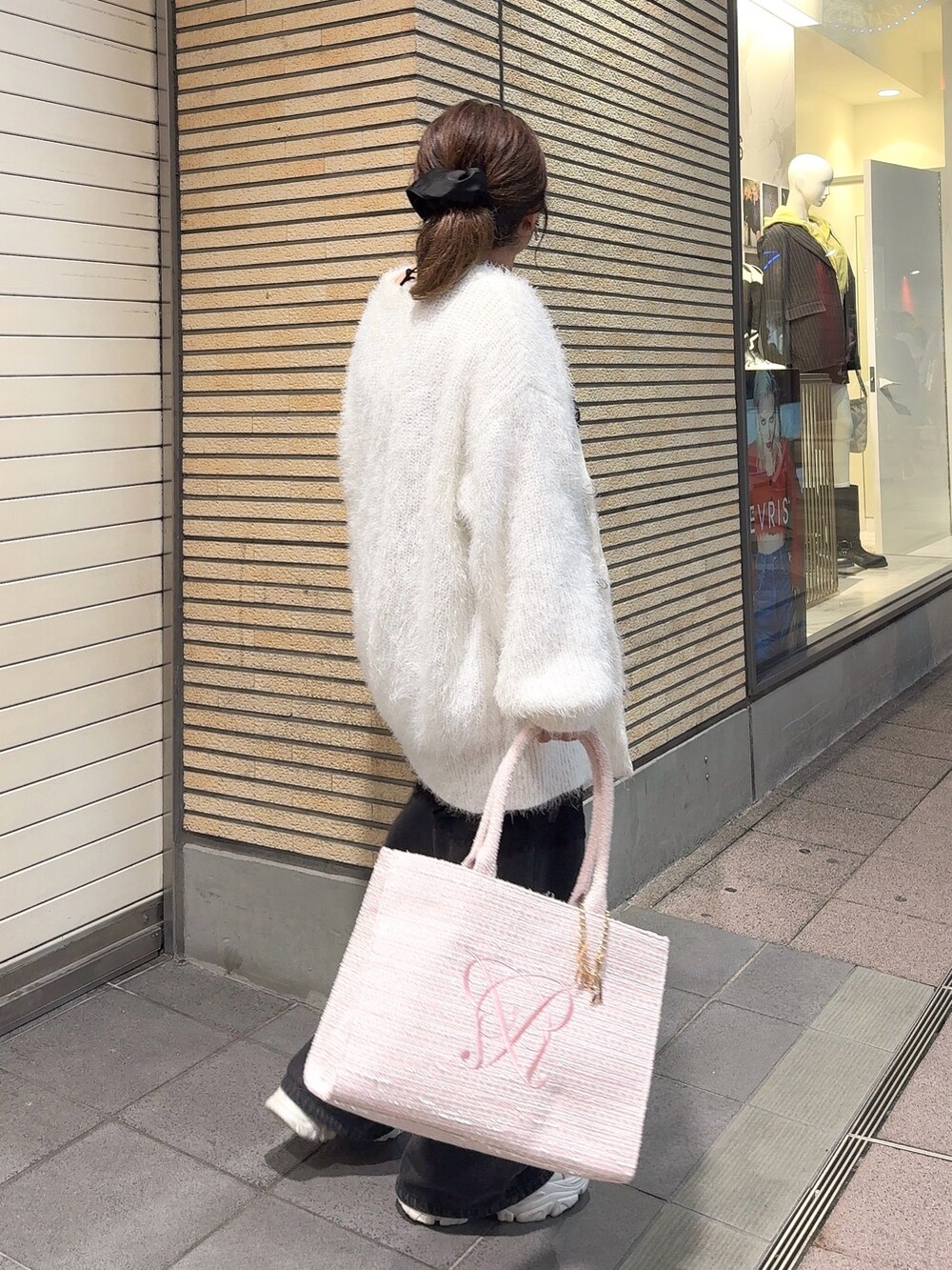 ホワイト系のカーディガン/ボレロ、ピンク系のトートバッグ、ブラック系のデニムパンツを着用したレディースの秋コーディネートの2枚目の写真