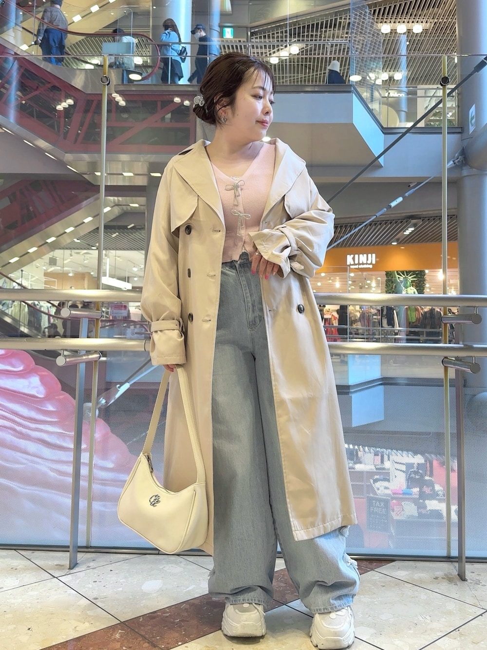 ベージュ系のトレンチコート、ピンク系のカーディガン/ボレロ、ホワイト系のショルダーバッグを着用したレディースの春コーディネートの2枚目の写真