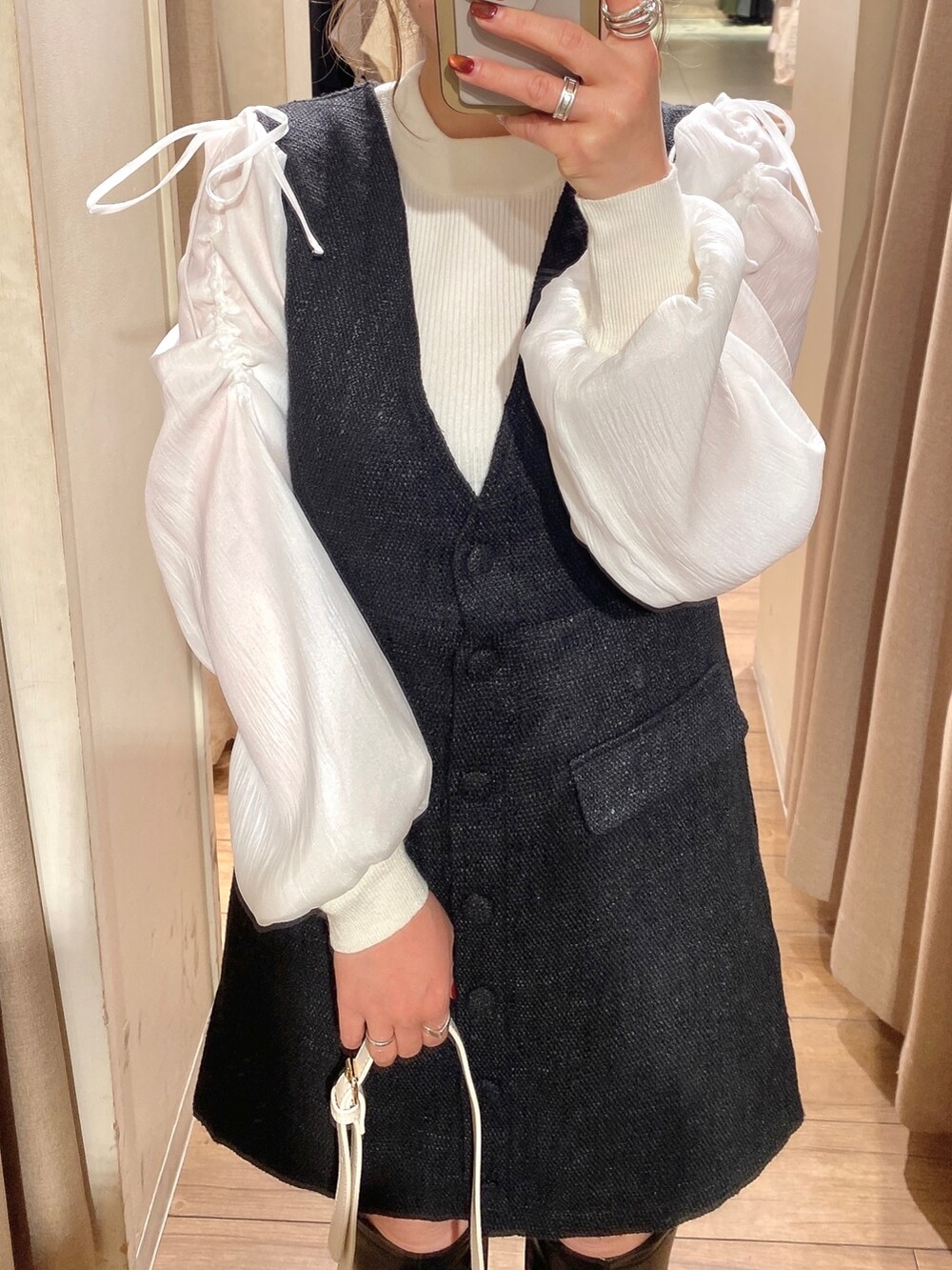 ホワイト系のニット/セーター、ブラック系のワンピース、ブラック系のブーツを着用したレディースの冬コーディネートの2枚目の写真