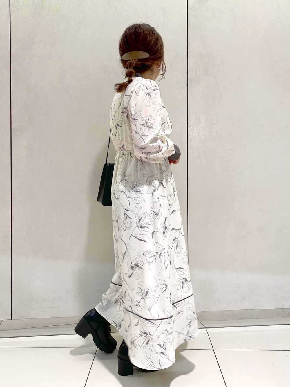 ホワイト系のワンピース、ブラック系のブーツ、ブラック系のショルダーバッグを着用したレディースの秋コーディネートの2枚目の写真