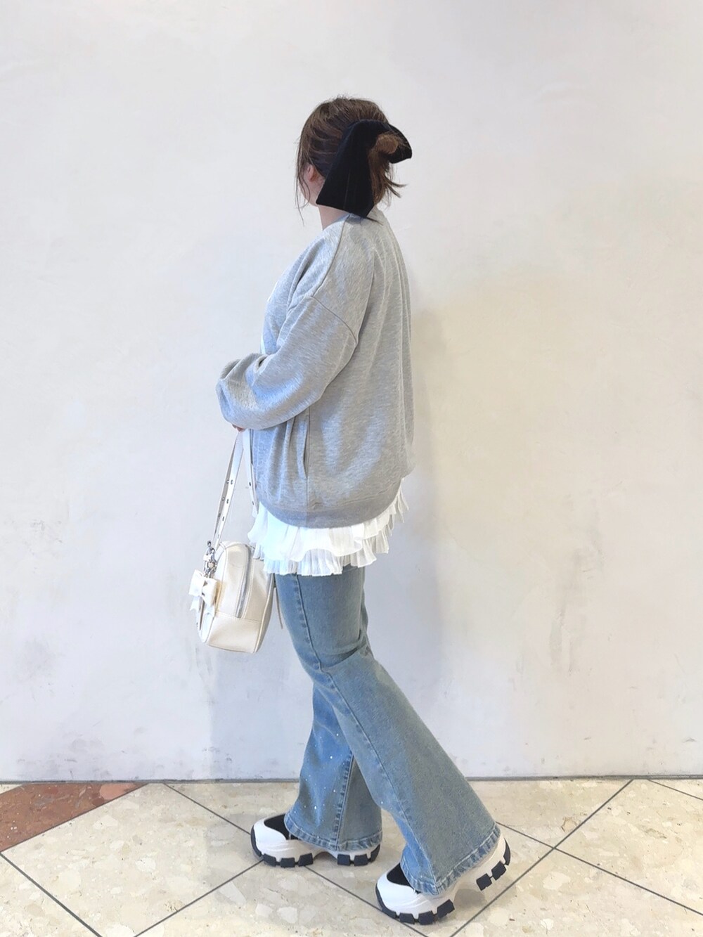 グレー系のTシャツ/カットソー、ホワイト系のワンピース、ホワイト系のショルダーバッグを着用したレディースの冬コーディネートの2枚目の写真