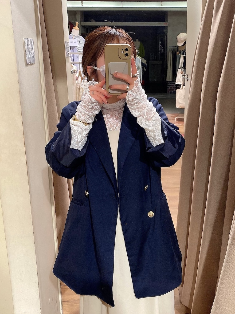 ブルー系のテーラードジャケット、ベージュ系のワンピース、ホワイト系のTシャツ/カットソーを着用したレディースの冬コーディネートの2枚目の写真