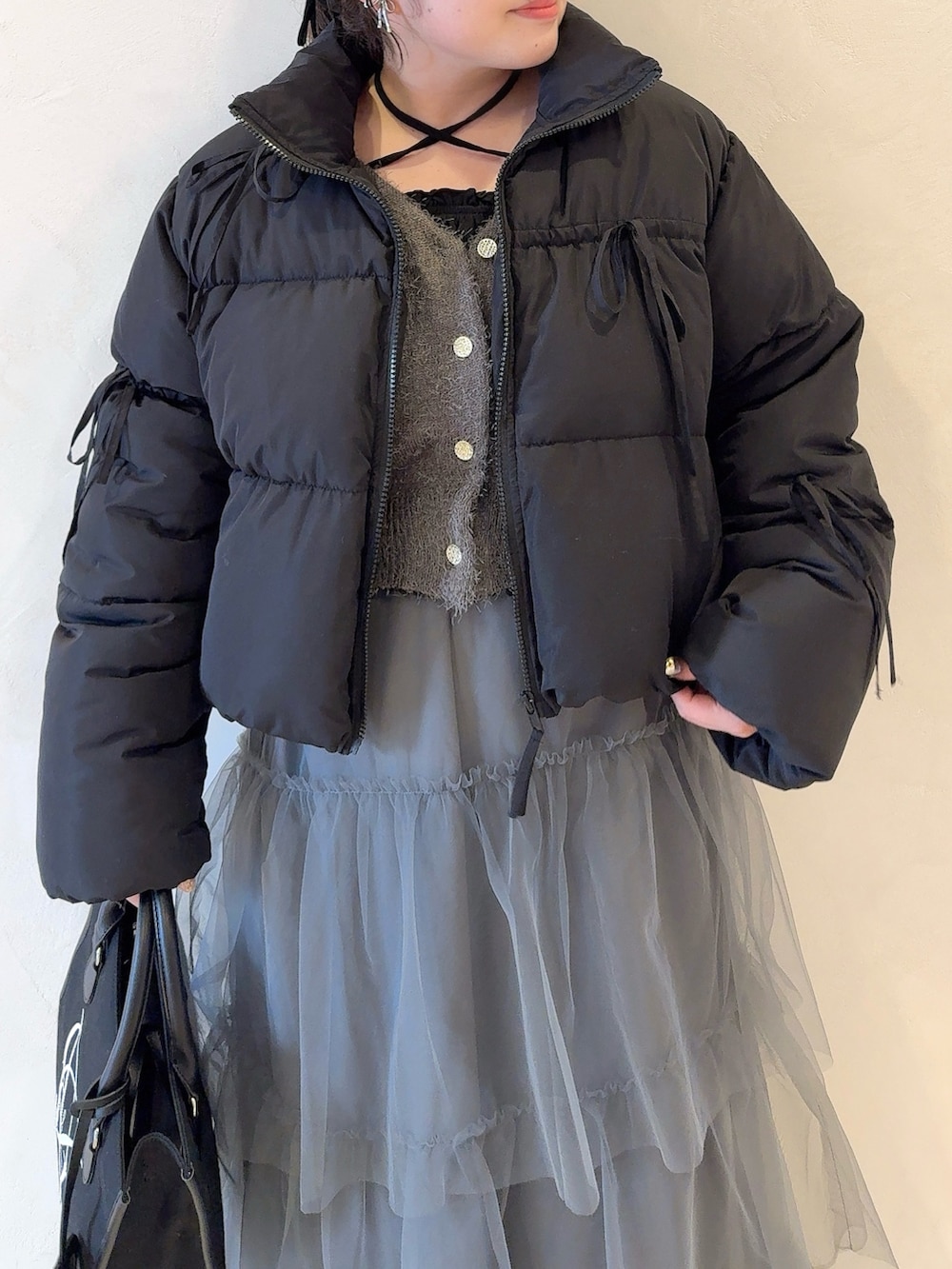 ブラック系のダウンジャケット/コート、グレー系のカーディガン/ボレロ、グレー系のワンピースを着用したレディースの冬コーディネートの3枚目の写真