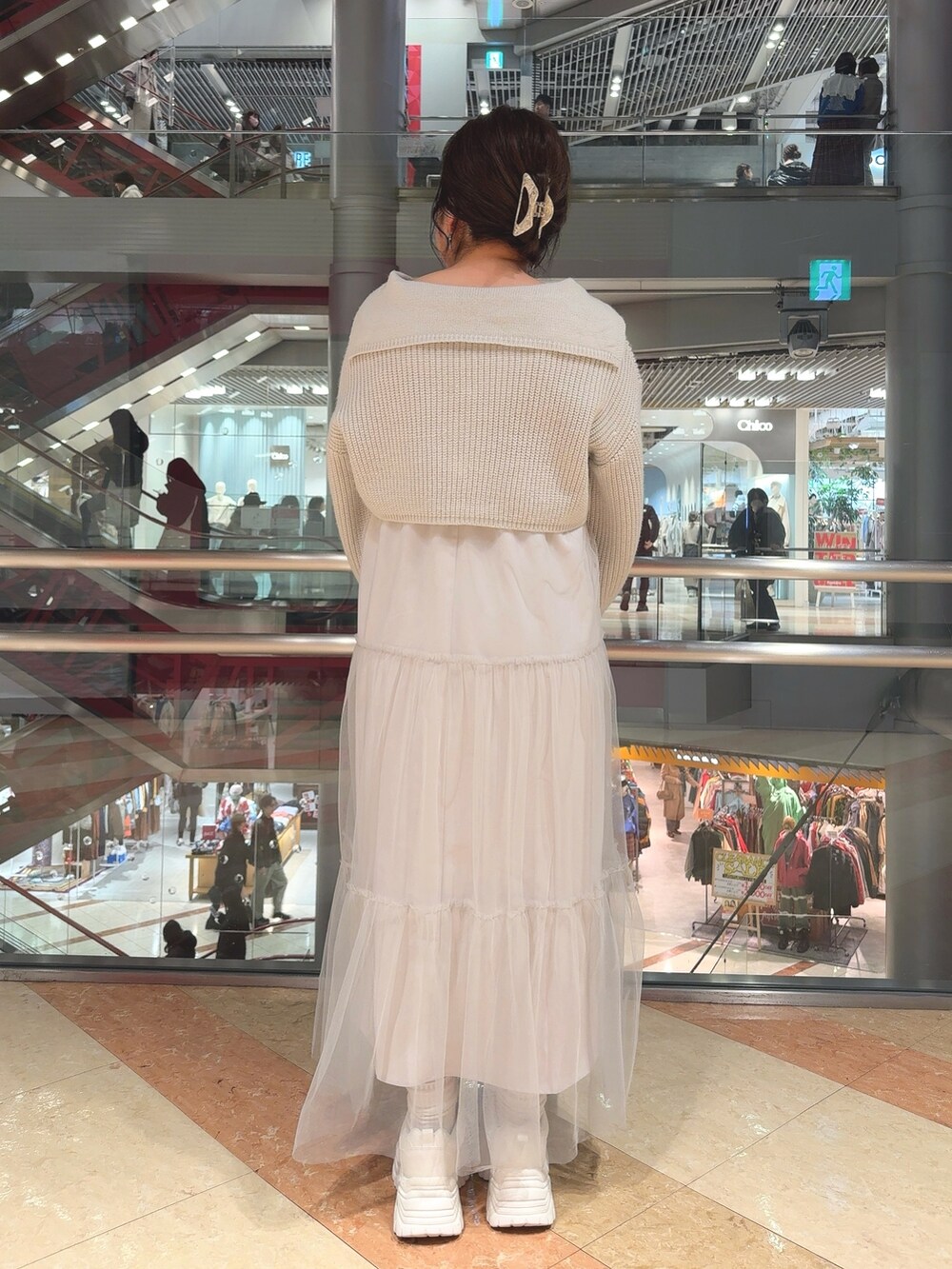 グリーン系のワンピース、ブラック系のトートバッグ、ホワイト系のスニーカーを着用したレディースの冬コーディネートの3枚目の写真