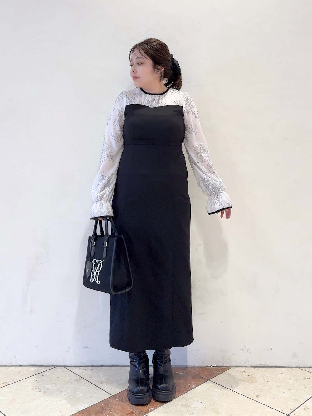 ホワイト系のドレス、ブラック系のトートバッグを着用したレディースの冬コーディネートの2枚目の写真