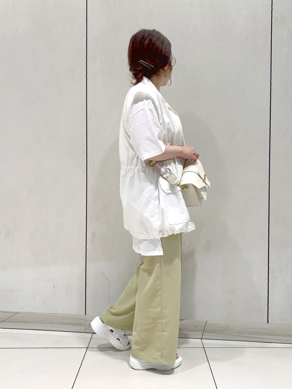 グリーン系のスラックス、ホワイト系のTシャツ/カットソー、ホワイト系のその他アウターを着用したレディースの春コーディネートの2枚目の写真