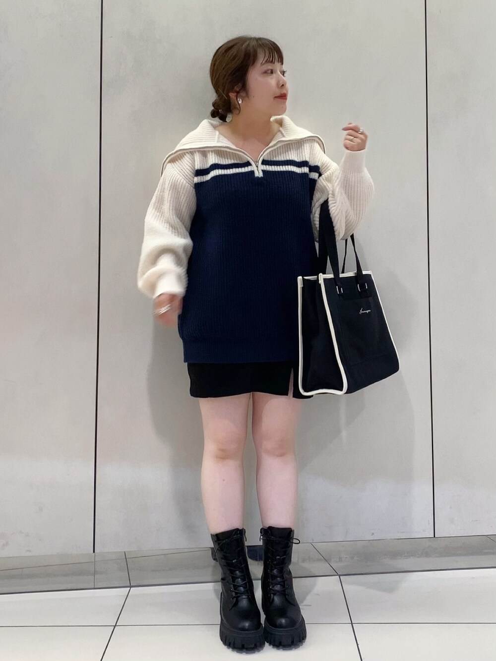 ブルー系のニット/セーター、ブラック系のスカート、ブラック系のトートバッグを着用したレディースの夏コーディネートの2枚目の写真