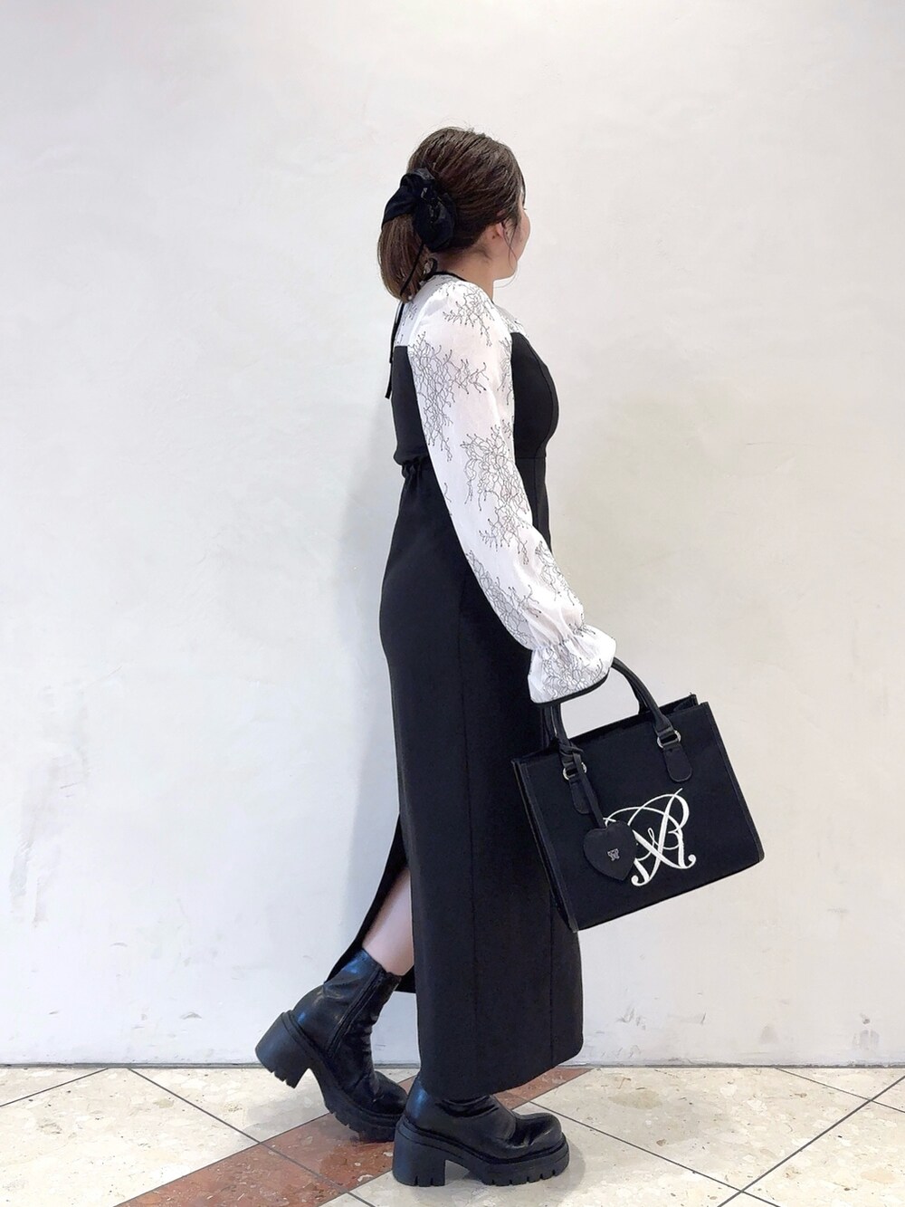 ホワイト系のドレス、ブラック系のトートバッグを着用したレディースの冬コーディネートの4枚目の写真