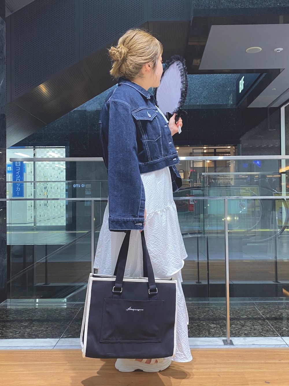 ホワイト系のスカート、ホワイト系のTシャツ/カットソー、ブルー系のデニムジャケットを着用したレディースの春コーディネートの2枚目の写真