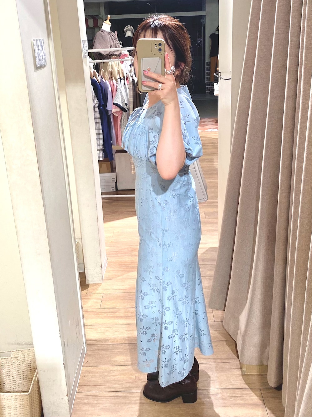 ブルー系のワンピース、ブラウン系のブーツ、ホワイト系のショルダーバッグを着用したレディースの夏コーディネートの3枚目の写真