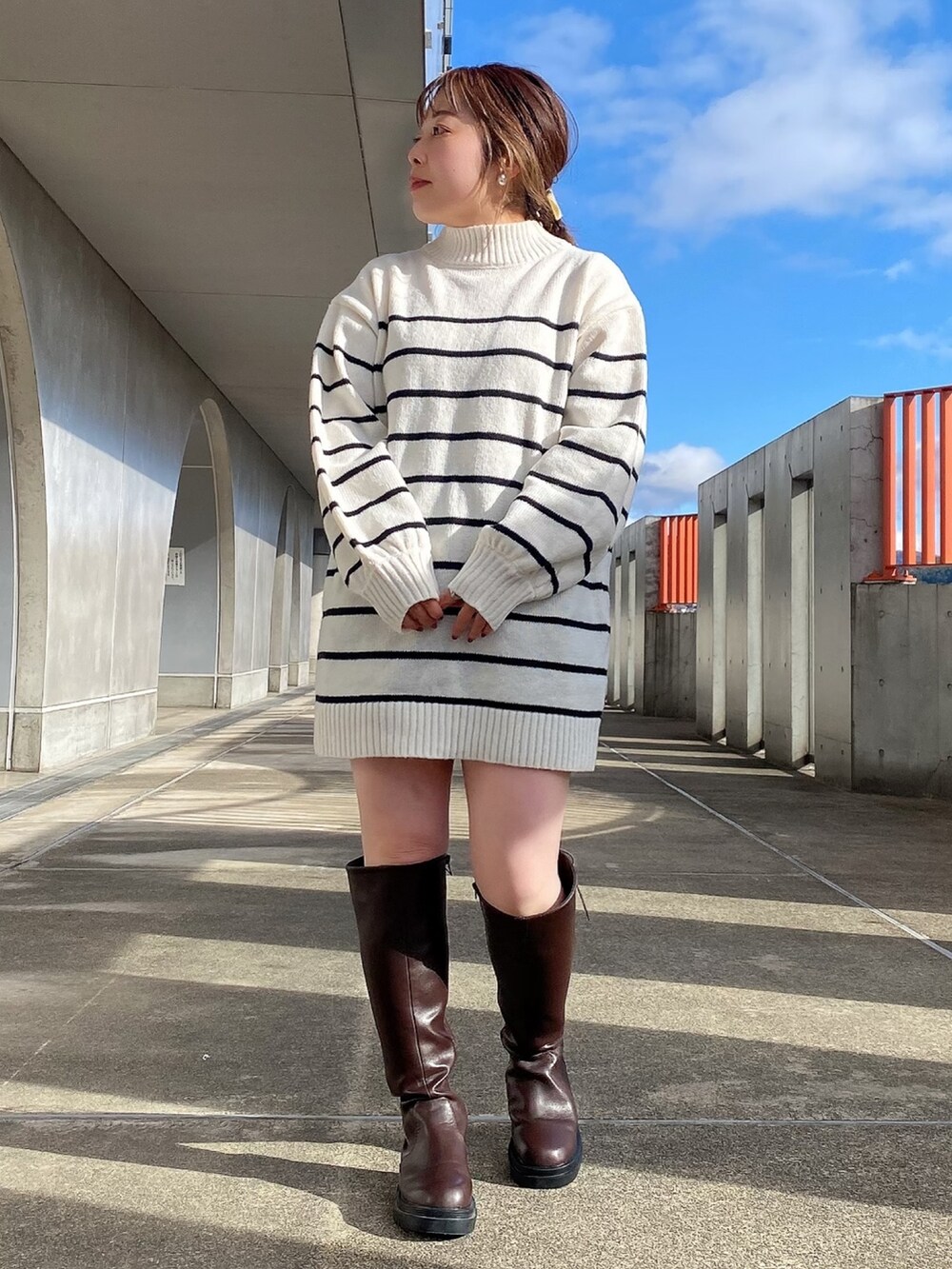 ホワイト系のニット/セーター、ブラウン系のブーツを着用したレディースの冬コーディネートの2枚目の写真