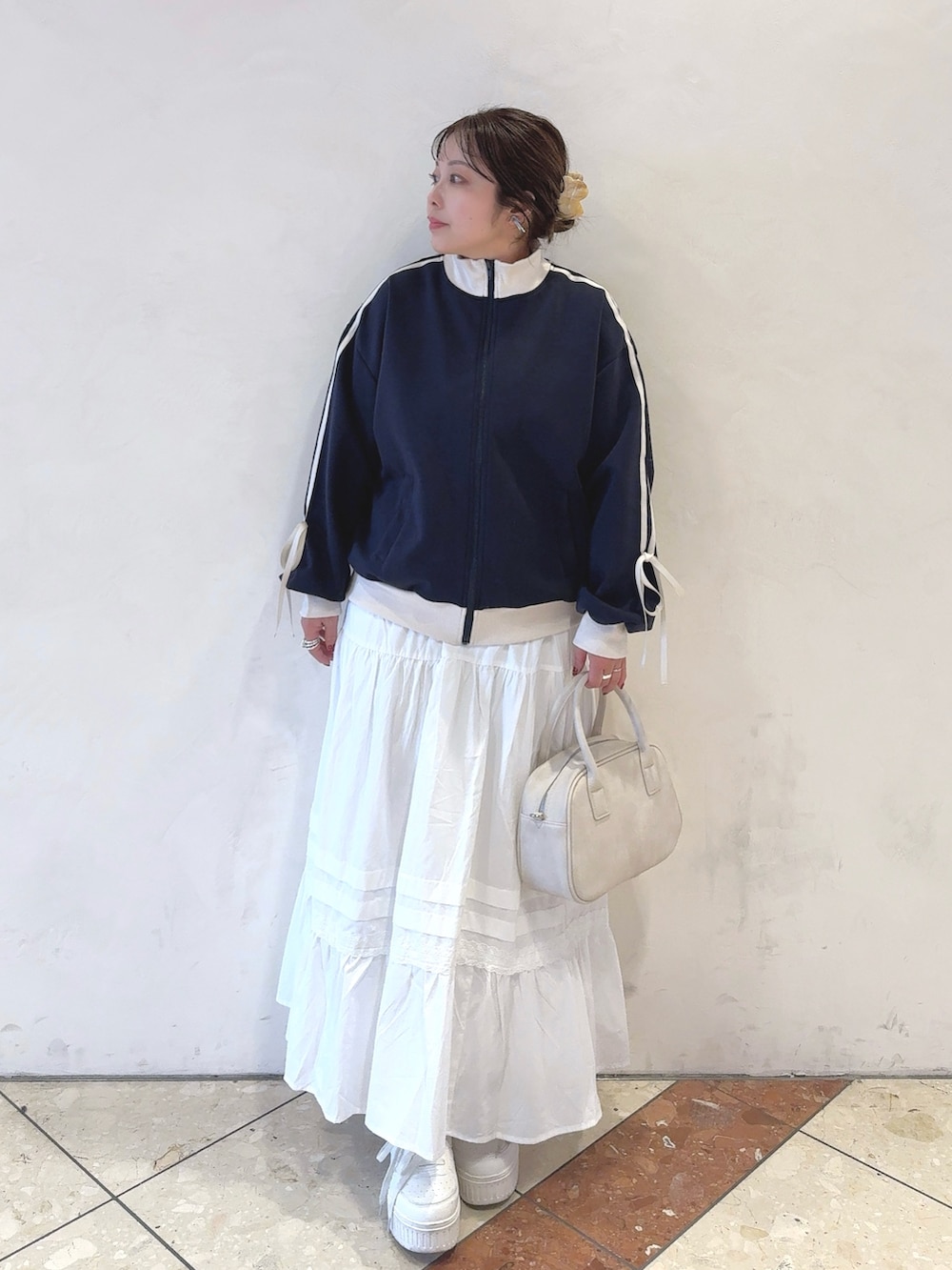 ブルー系のカーディガン/ボレロ、ホワイト系のスカート、ホワイト系のショルダーバッグを着用したレディースの冬コーディネートの2枚目の写真