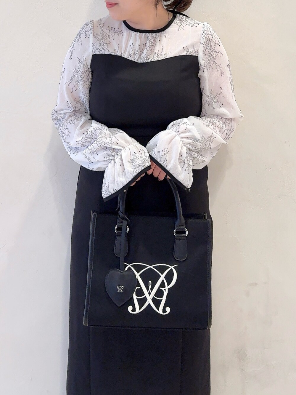 ホワイト系のドレス、ブラック系のトートバッグを着用したレディースの冬コーディネートの5枚目の写真