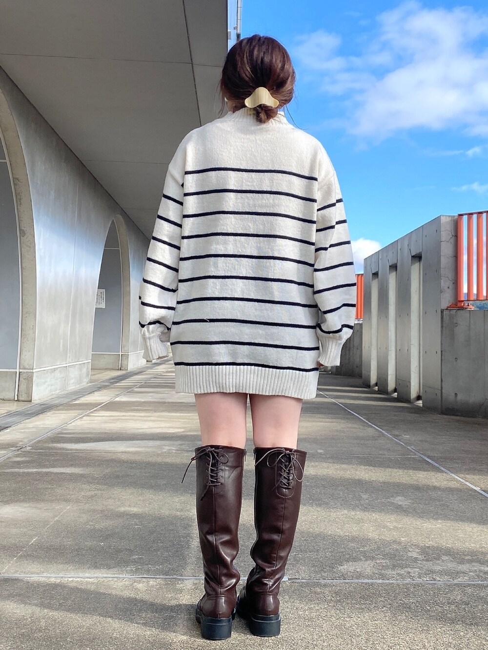 ホワイト系のニット/セーター、ブラウン系のブーツを着用したレディースの冬コーディネートの3枚目の写真