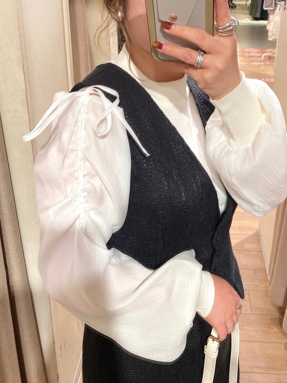 ホワイト系のニット/セーター、ブラック系のワンピース、ブラック系のブーツを着用したレディースの冬コーディネートの3枚目の写真