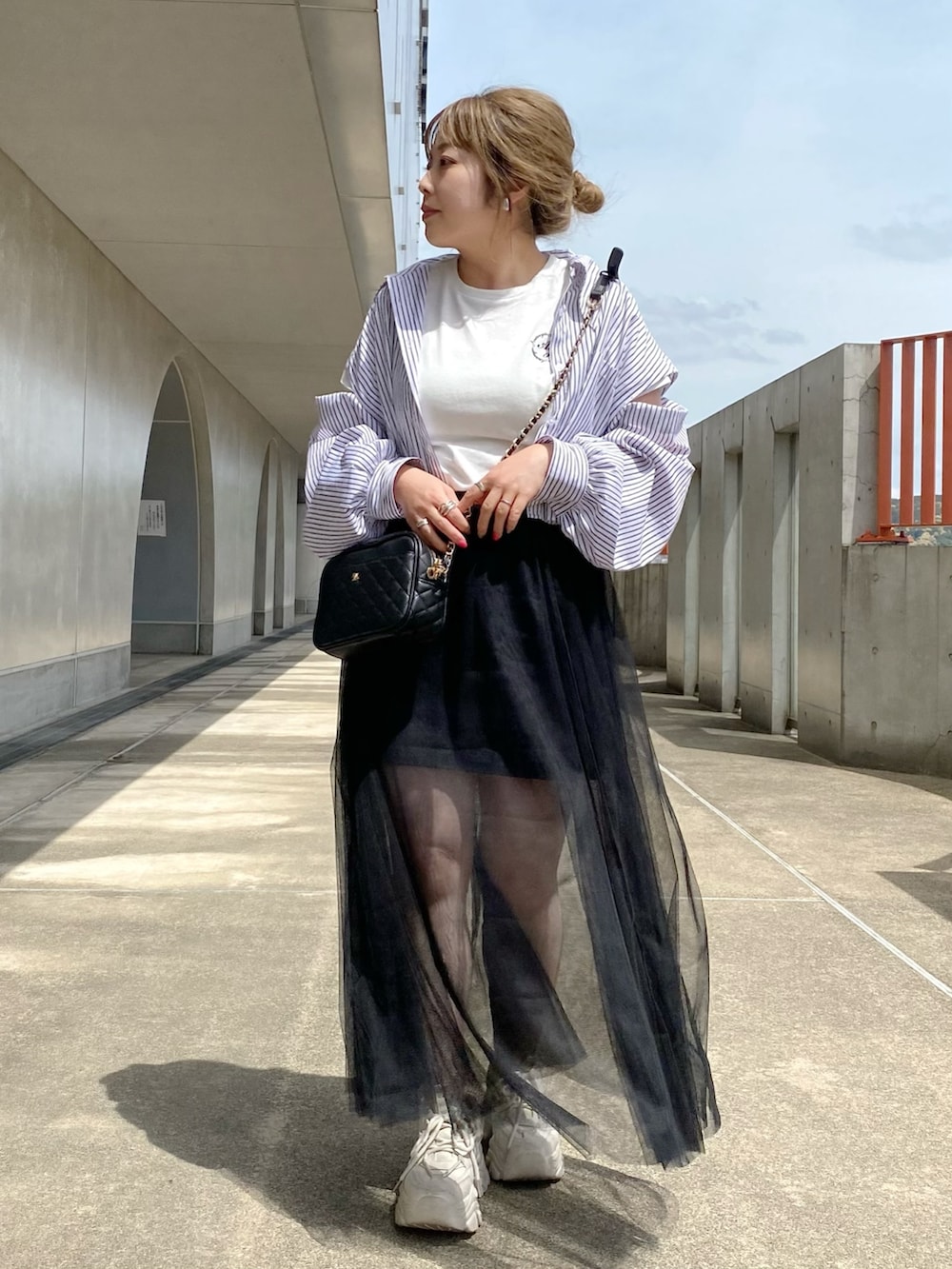 ホワイト系のTシャツ/カットソー、ブラック系のシャツ/ブラウス、ブラック系のスカートを着用したレディースの春コーディネートの2枚目の写真