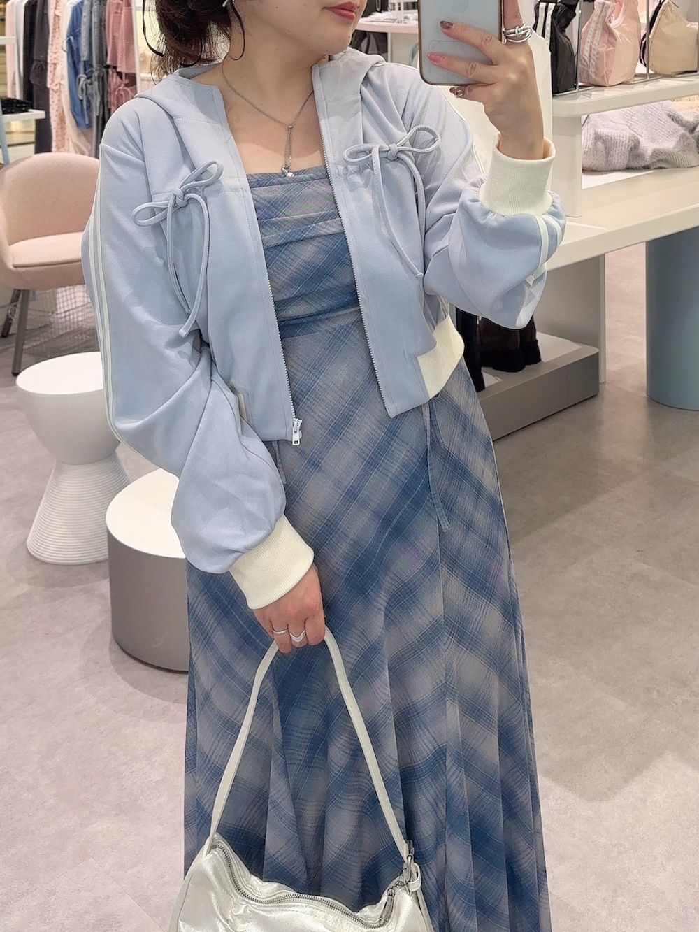 ブルー系のTシャツ/カットソー、ブラック系のワンピース、ホワイト系のショルダーバッグを着用したレディースの秋コーディネートの2枚目の写真