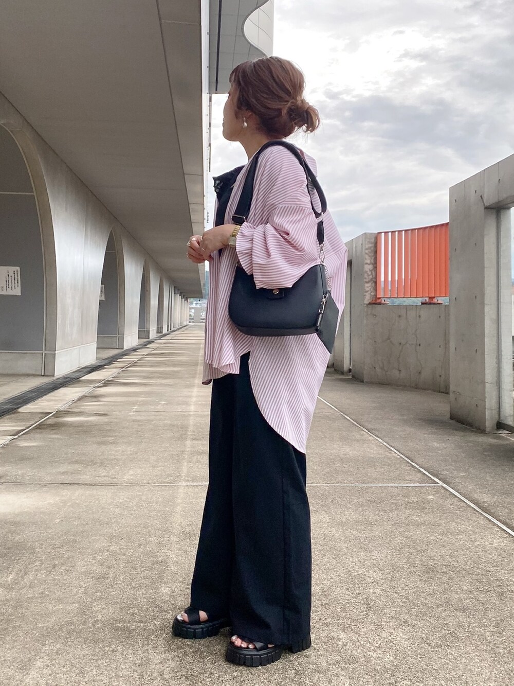 ピンク系のシャツ/ブラウス、ブラック系のサロペット/オーバーオール、ブラック系のサンダルを着用したレディースの夏コーディネートの4枚目の写真