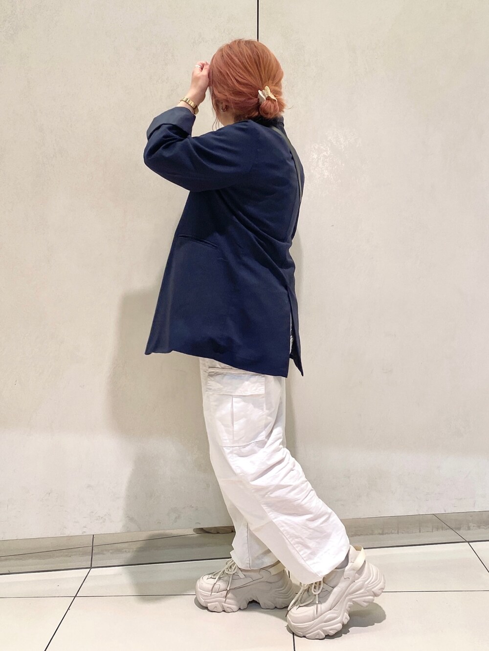 ブルー系のテーラードジャケット、ホワイト系のシャツ/ブラウス、ブラック系のショルダーバッグを着用したレディースの春コーディネートの2枚目の写真