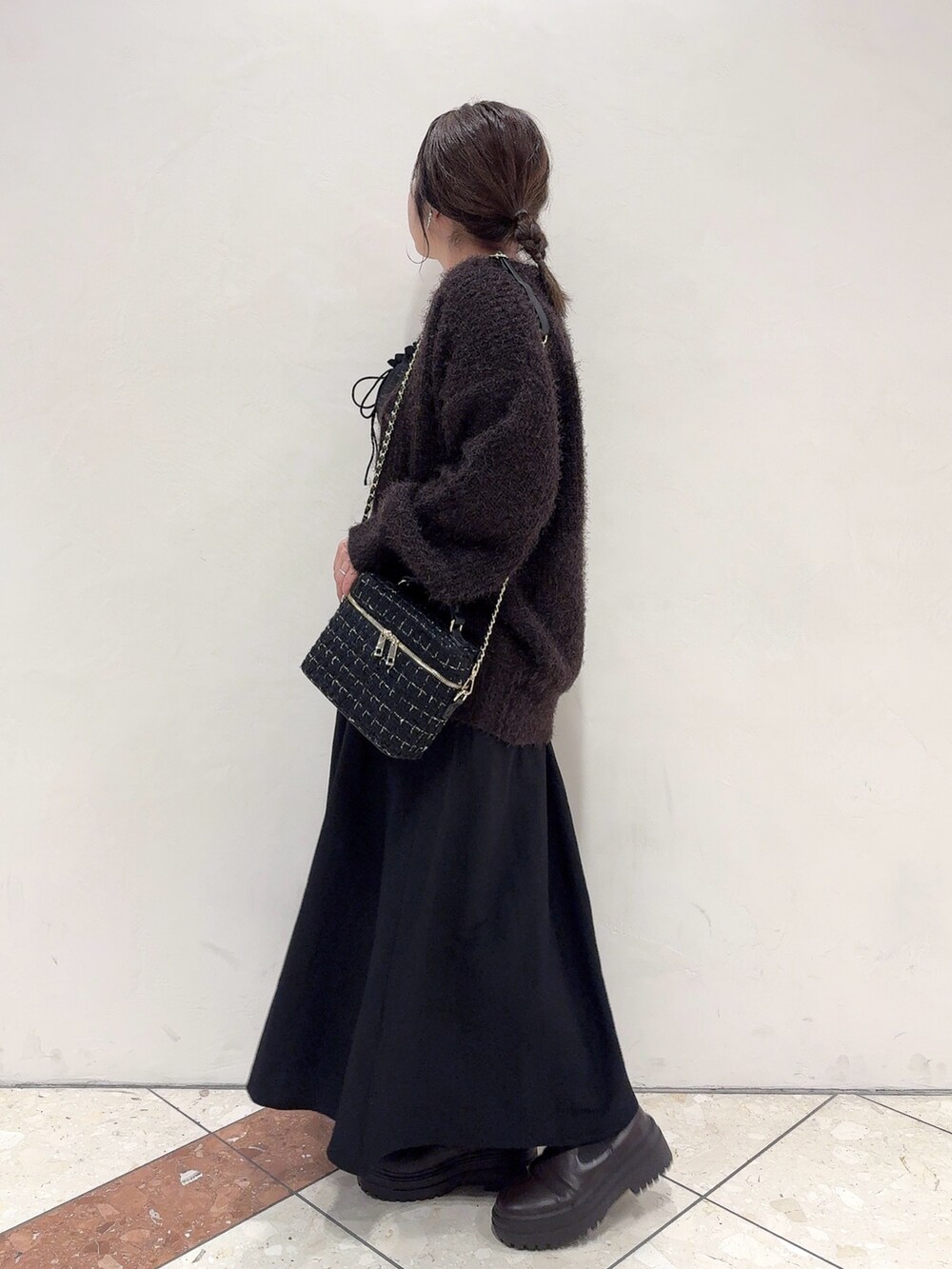 ブラウン系のカーディガン/ボレロ、ブラック系のワンピース、ブラック系のショルダーバッグを着用したレディースの秋コーディネートの3枚目の写真