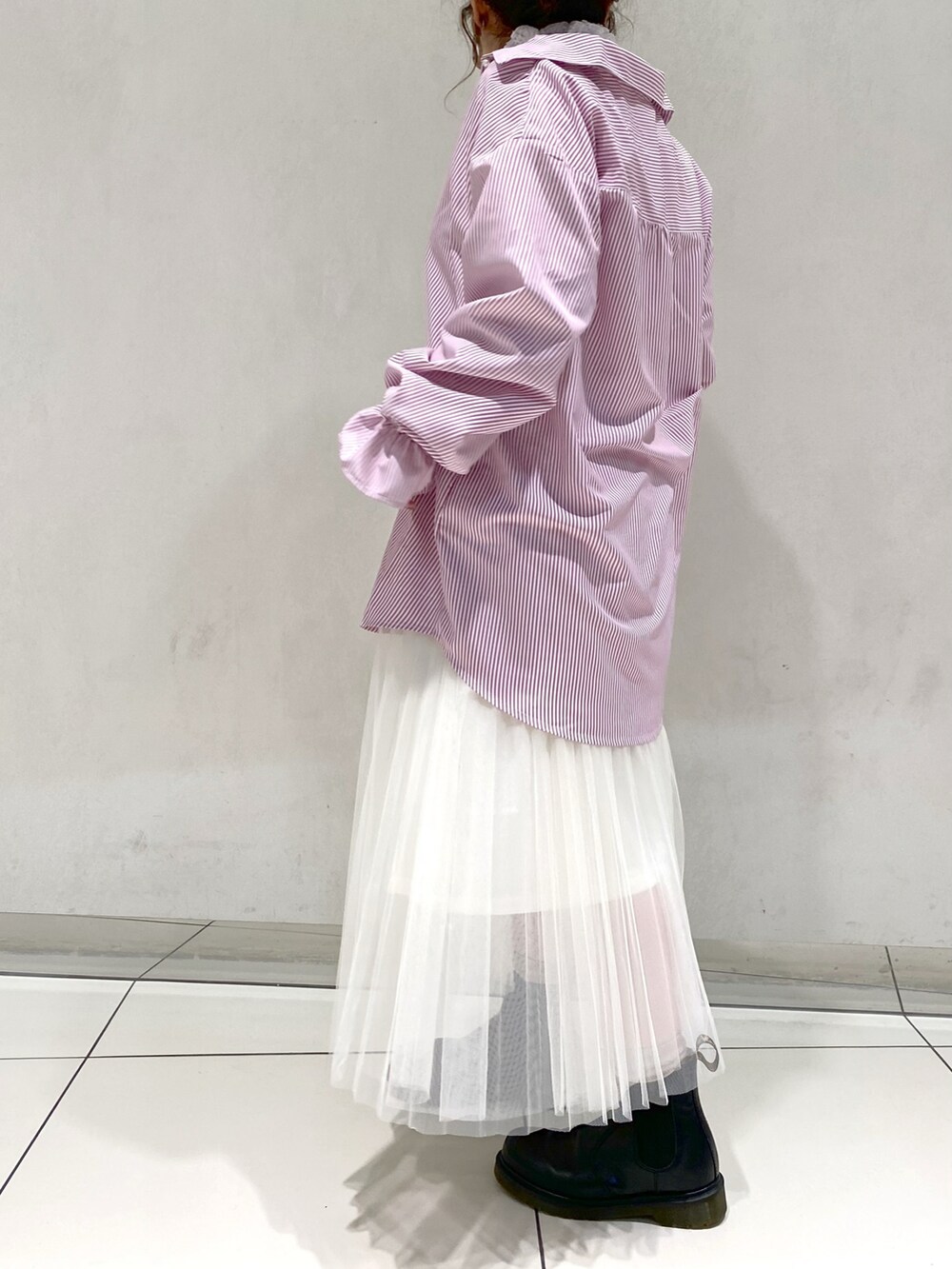 ピンク系のシャツ/ブラウス、ホワイト系のスカート、ブラック系のブーツを着用したレディースの冬コーディネートの2枚目の写真