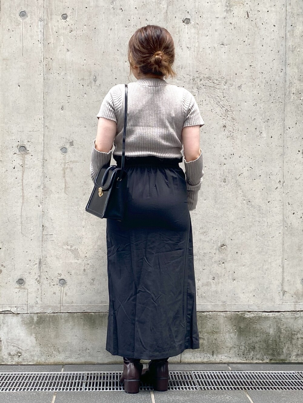 ブラック系のスカート、ブラウン系のブーツ、ブラウン系のニット/セーターを着用したレディースの夏コーディネートの3枚目の写真