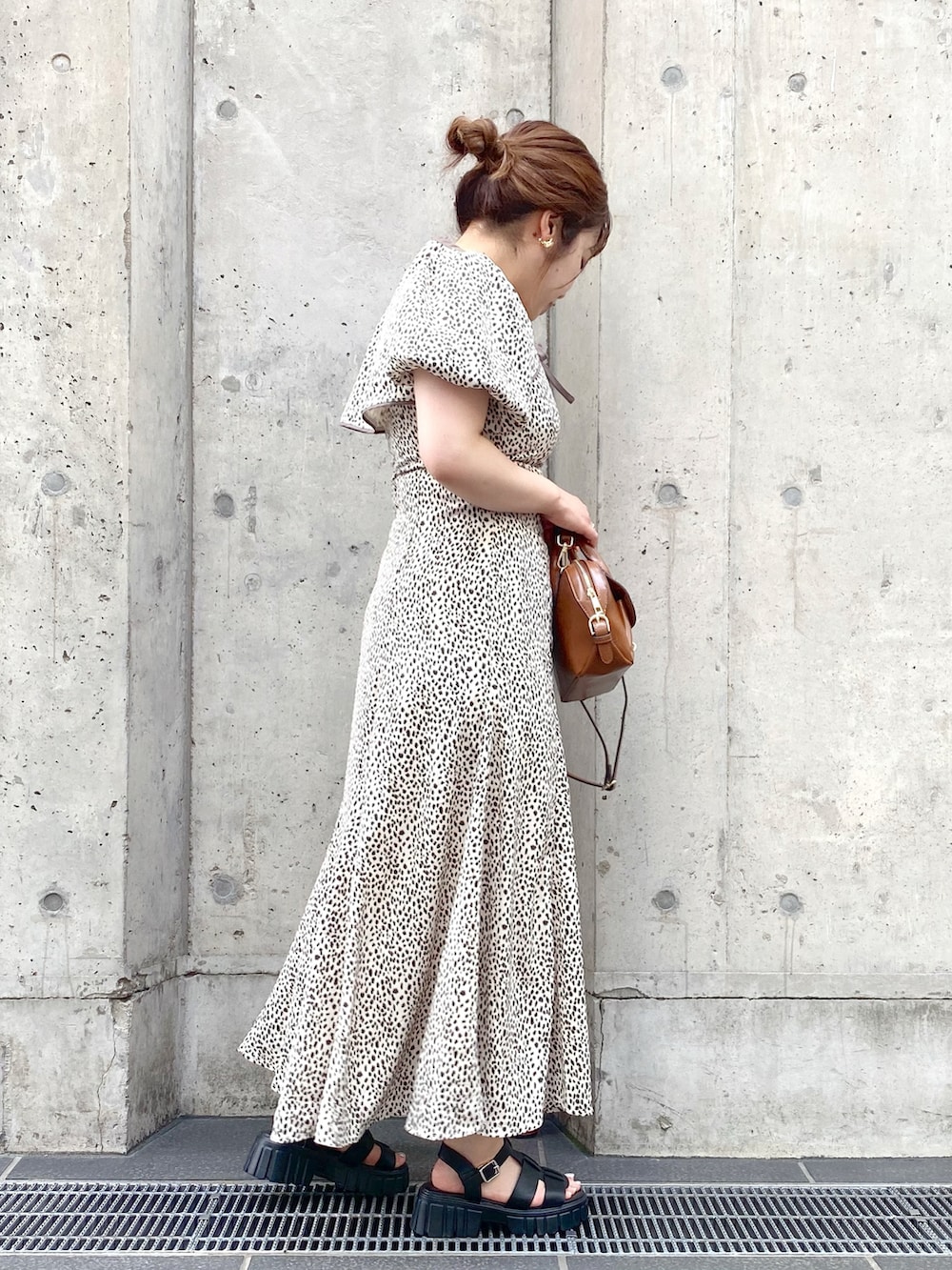 イエロー系のショルダーバッグ、ホワイト系のワンピース、ブラック系のサンダルを着用したレディースの夏コーディネートの4枚目の写真