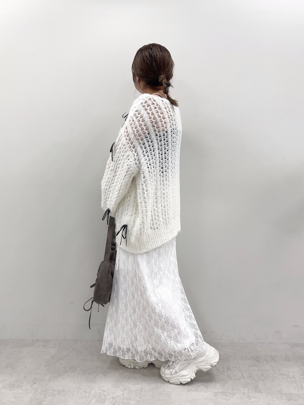 ホワイト系のニット/セーター、ブラック系のショルダーバッグ、ホワイト系のスカートを着用したレディースの秋コーディネートの2枚目の写真