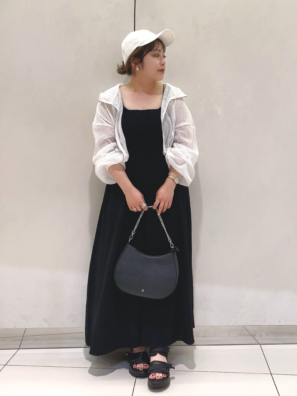 ブラック系のワンピース、ホワイト系のジャケット/アウター、ブラック系のショルダーバッグを着用したレディースの夏コーディネートの2枚目の写真