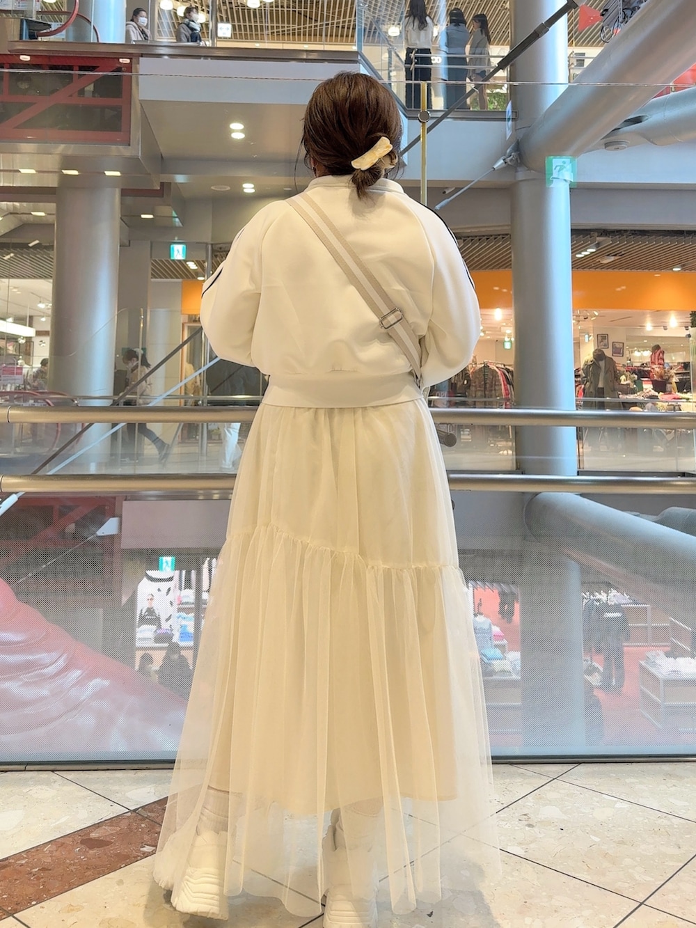 ホワイト系のブルゾン、ホワイト系のスカート、ホワイト系のスニーカーを着用したレディースの冬コーディネートの3枚目の写真