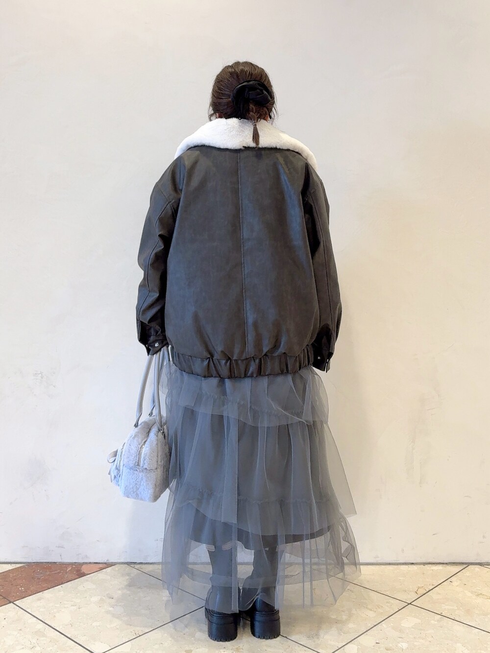 ブラック系のブルゾン、グレー系のワンピース、ブルー系のショルダーバッグを着用したレディースの冬コーディネートの4枚目の写真