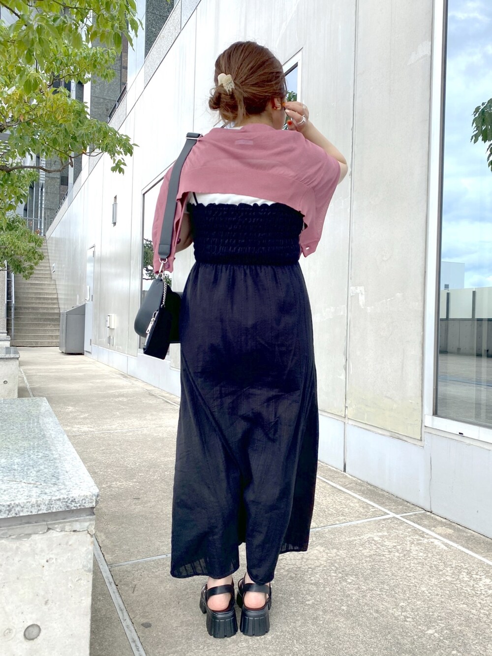 ブラック系のワンピース、ブラック系のサンダル、ホワイト系のTシャツ/カットソーを着用したレディースの夏コーディネートの3枚目の写真