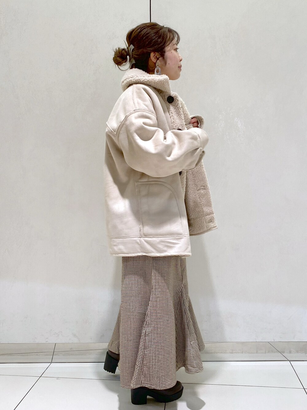 ホワイト系のニット/セーター、ベージュ系のムートンコート、ベージュ系のスカートを着用したレディースの秋コーディネートの3枚目の写真