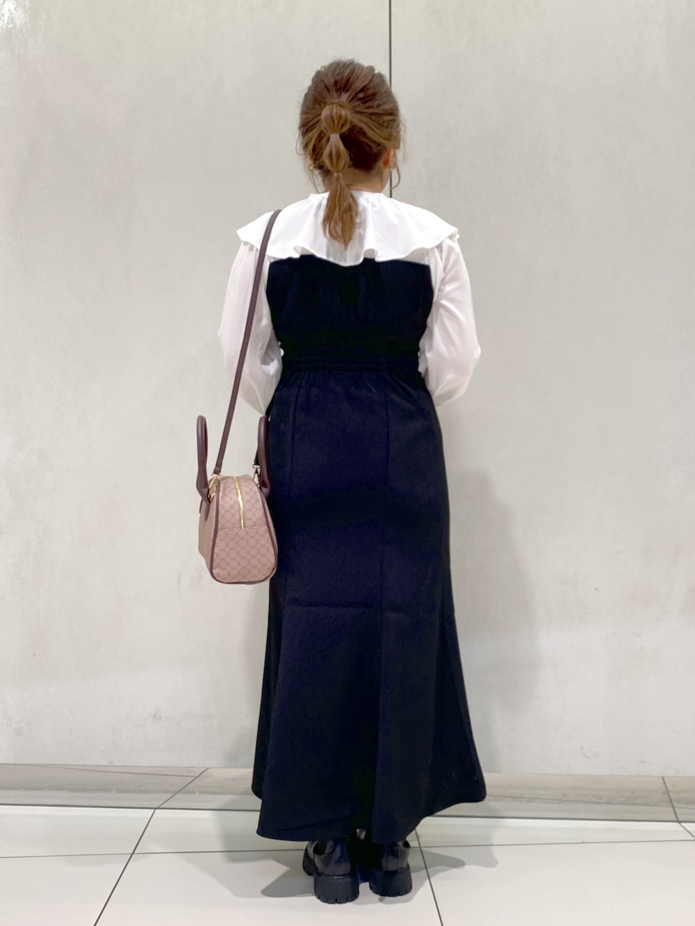 ブラック系のワンピース、ブラウン系のショルダーバッグ、ブラック系のブーツを着用したレディースの秋コーディネートの3枚目の写真