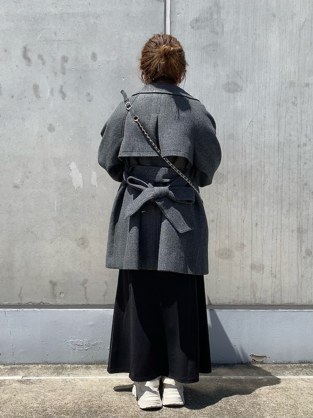 グレー系のステンカラーコート、ブラック系のショルダーバッグ、ブラック系のスカートを着用したレディースの夏コーディネートの4枚目の写真