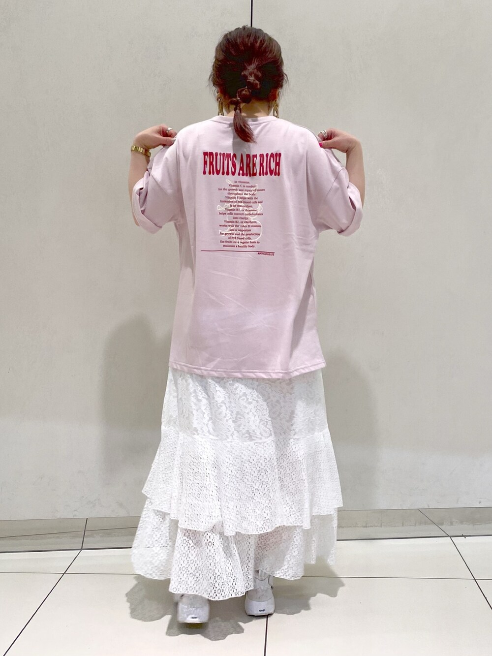 ピンク系のTシャツ/カットソー、ホワイト系のスカート、ホワイト系のスニーカーを着用したレディースの春コーディネートの3枚目の写真